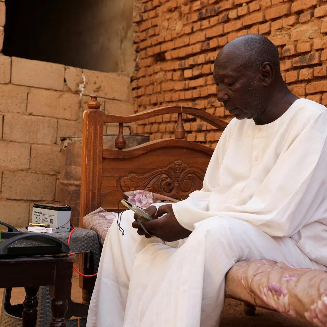 Retired Police Major General Kahil Mohamed Al-Amin, whose son was slaughtered by the Rapid Support Forces (RSF), sits on a bed during an interview, in the Salha area, south of Omdurman, Sudan, June 7, 2026. REUTERS/Stringer