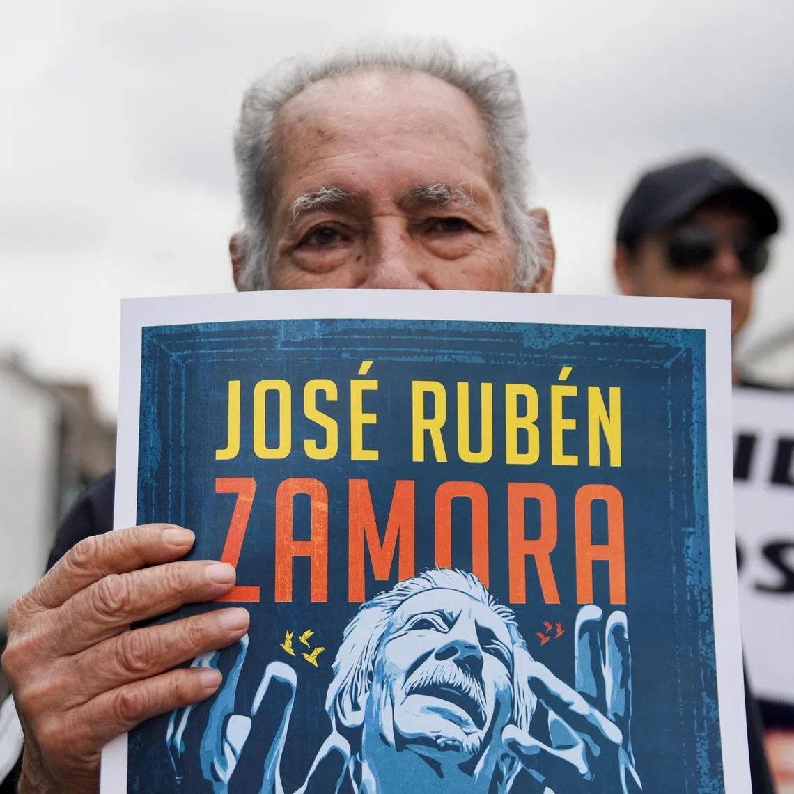 A man holds a sign with an image depicting journalist Jose Ruben Zamora during a protest to demand his release from jail, in Guatemala City, Guatemala, September 18, 2025. REUTERS/Cristina Chiquin/File Photo