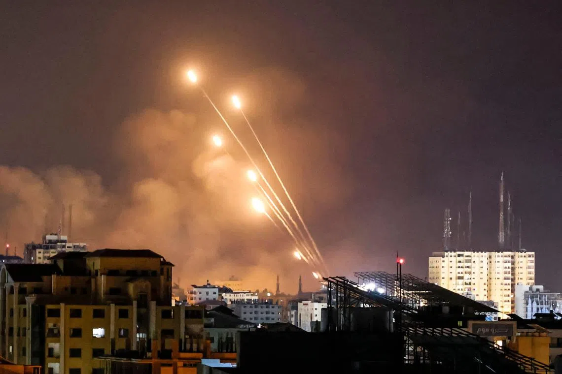 A salvo of rockets is fired by Palestinian militants from Gaza City toward Israel on Oct 8.