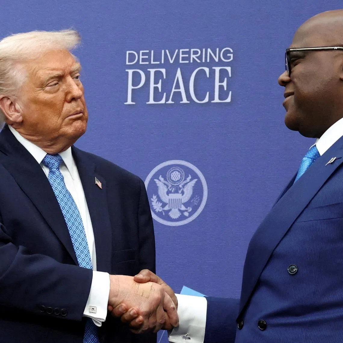 FILE PHOTO: U.S. President Donald Trump shakes hands with President of the Democratic Republic of the Congo Felix Tshisekedi during a signing ceremony at the U.S. Institute of Peace in Washington, D.C., U.S., December 4, 2025. REUTERS/Kevin Lamarque/File Photo