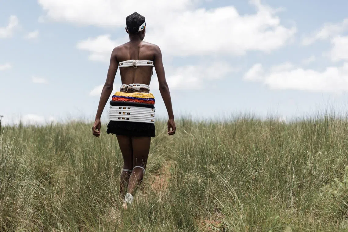A young maiden of the Nazareth Baptist Church, from the Ekuphakameni group, also known as the Shembe Church, dressed in traditional attire, climbs the holy moumtain to take part in a cultural dance on the Nhlangakazi Holy Mountain in Ndwedwe 85km north of Durban, on Jan 8, 2023. 