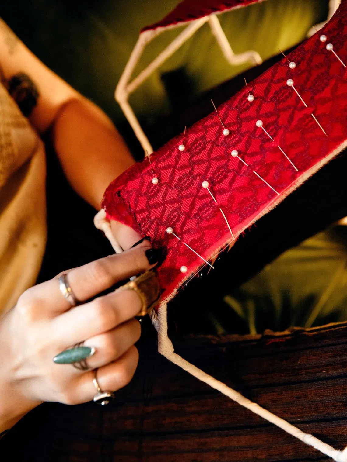 Ms Ivy Karlsgodt pins fabric to a Victorian-style lampshade frame in her home studio in New York, May 6, 2024. Viewers of her videos online find KarlsgodtÕs creations beautiful and her process meditative. (Justin J Wee for/The New York Times) 