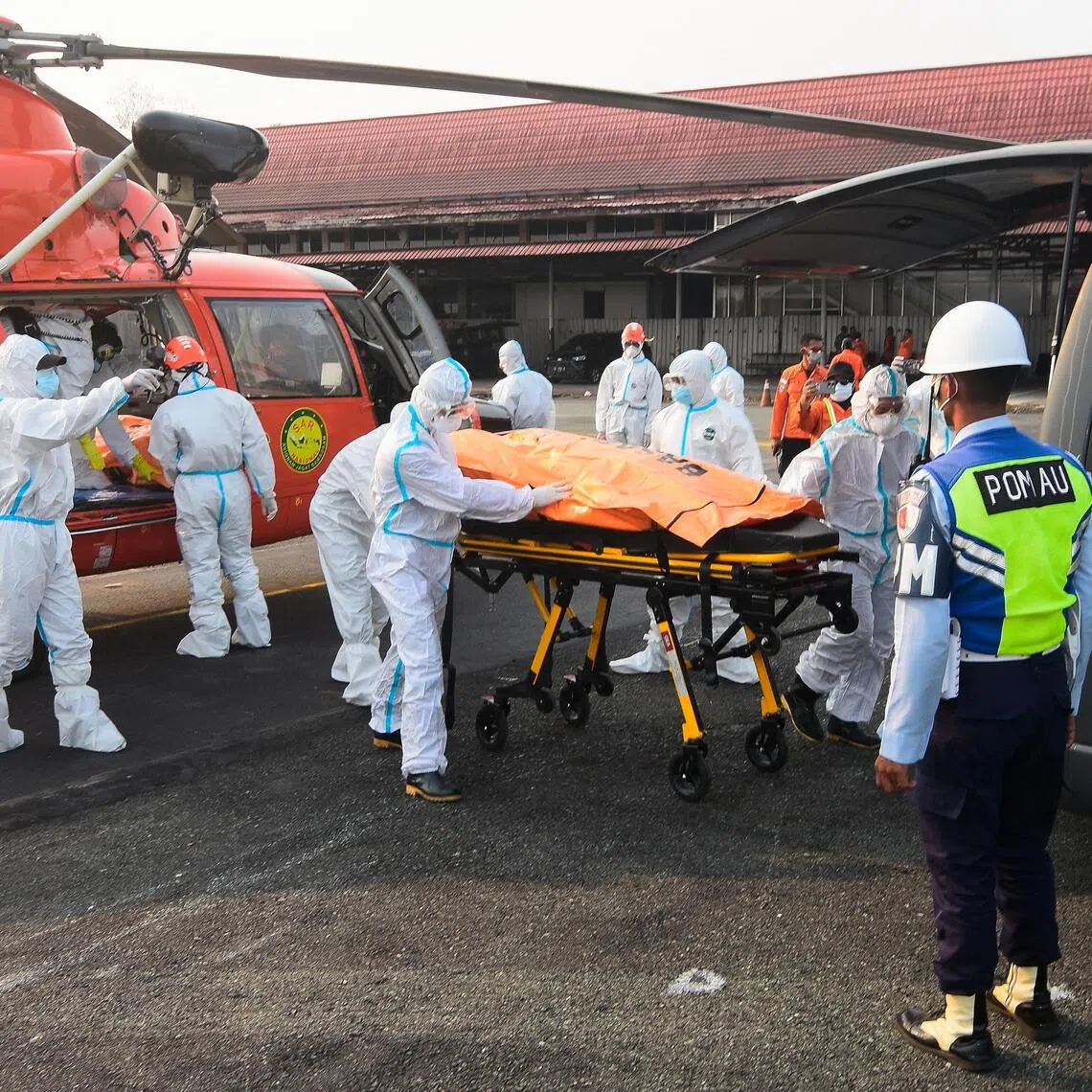 Rescuers in protective suits move the body of a victim recovered from the Virgo Transport 8 ferry on Sept 23.