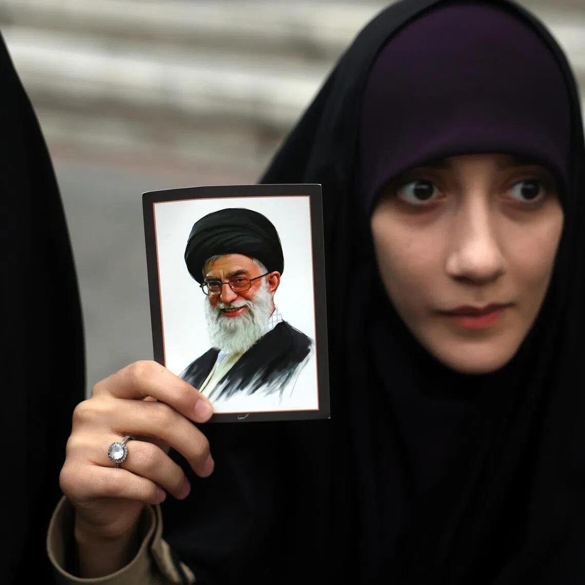 An Iranian woman holding a picture of Ayatollah Ali Khamenei, Iran's supreme leader, during anti-US and Israeli protests in Tehran on Feb 28.