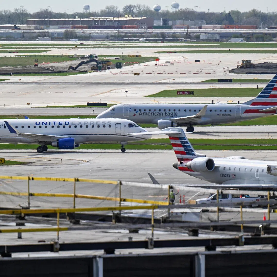 Planes operated by United Airlines and American Airlines taxi on the runway at Chicago O'Hare International Airport in Chicago on April 14, 2026. 