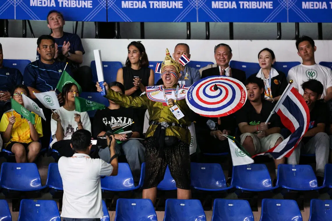 Superfan Thailand Khamthong cheering on the Thai women's badminton team in their semi-final win against Singapore at the Thammasat University.