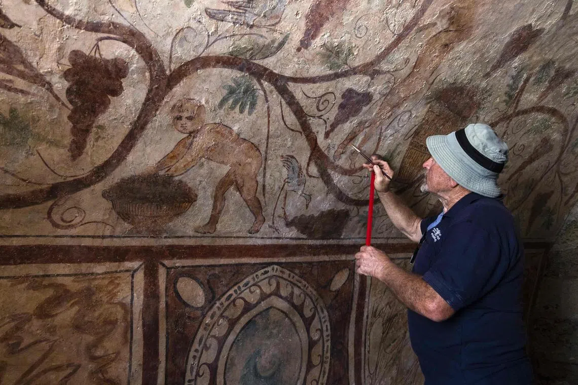 Conservation expert Vladimir Bitman working on ancient frescoes inside one of two ancient Roman tombs in the southern Israeli city of Ashkelon, on Aug 27.
