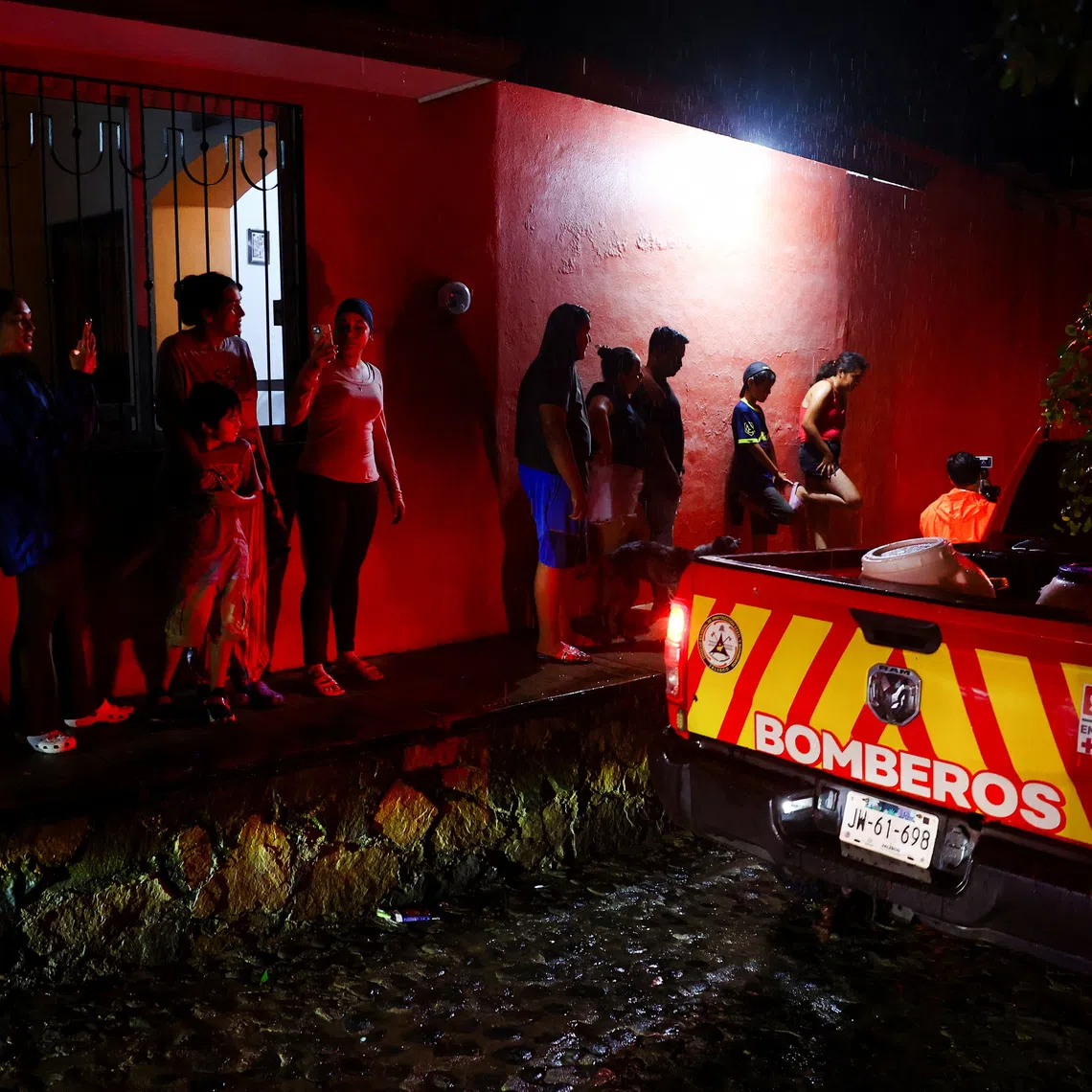 People, standing near an emergency vehicle, watch as the authorities assess whether the area needs to be evacuated as Hurricane Simon approaches Mexico's Pacific coast in Costalegre, Jalisco state, Mexico, October 11, 2026. REUTERS/Daniel Becerril