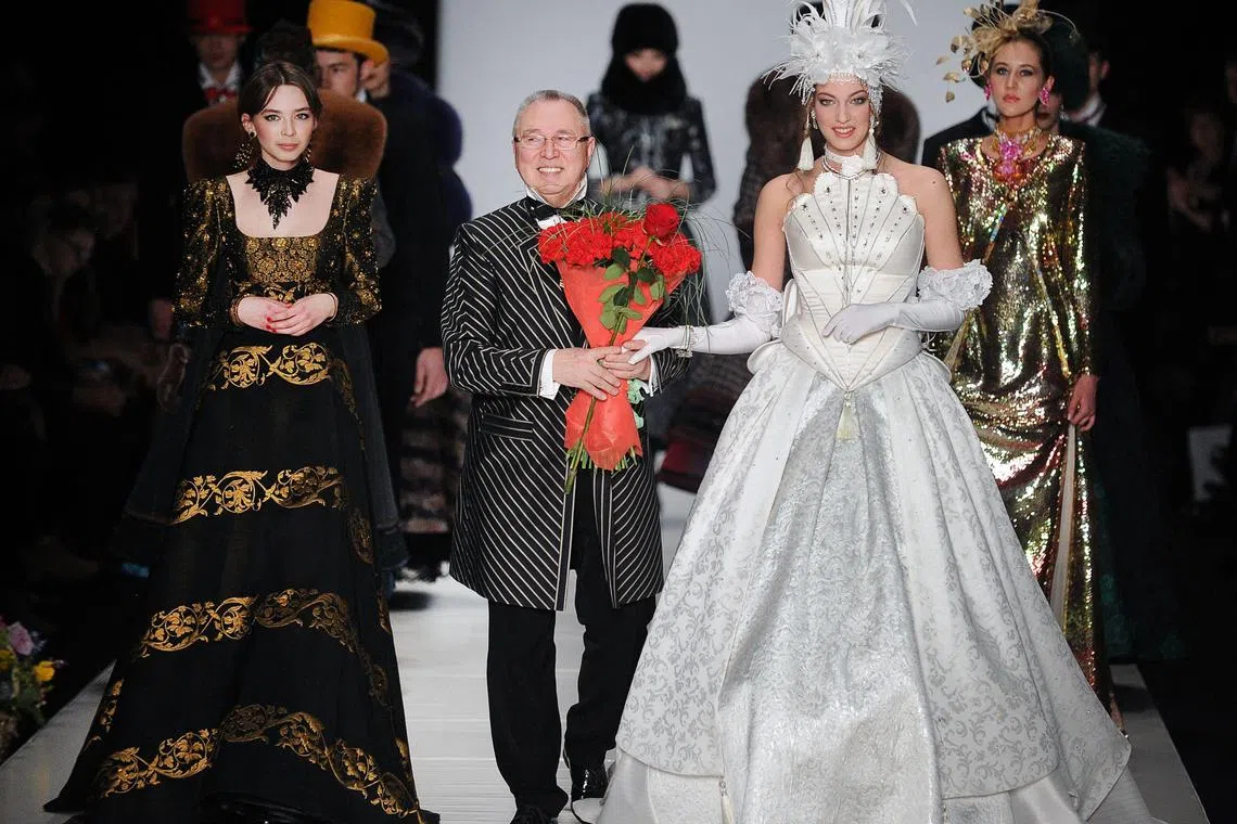 A 2013 photo shows Russian fashion designer Slava Zaitsev (centre) on stage with his models during Moscow Fashion Week.