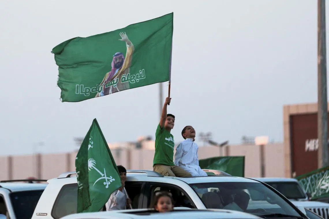 Celebrating Saudis hold the country's flag as they take part in a carnival in Riyadh marking National Day.