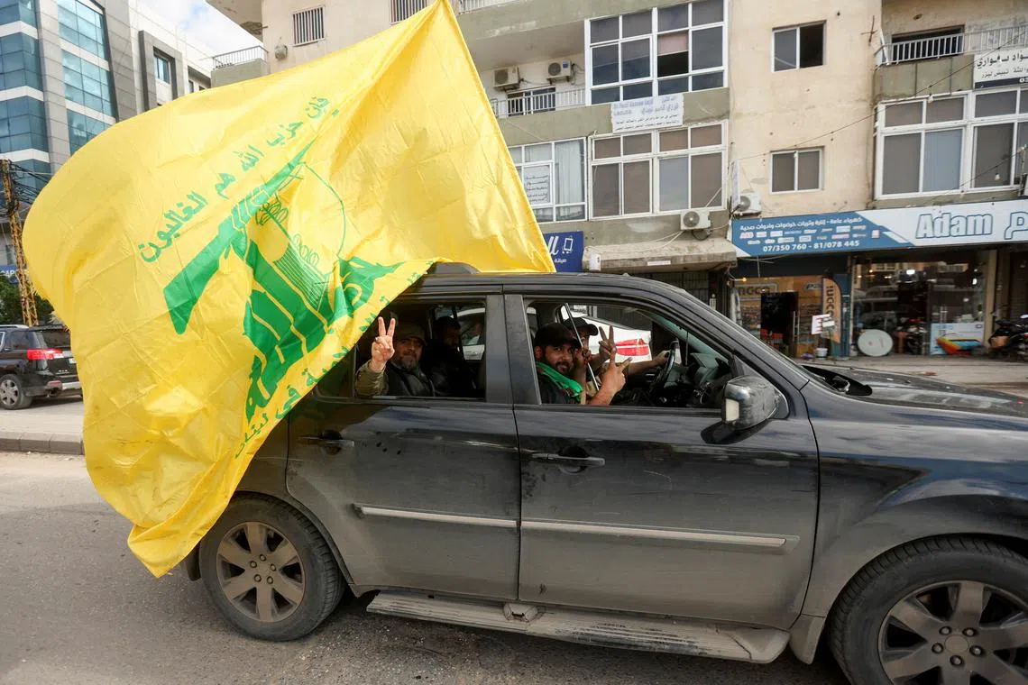 FILE PHOTO: A man gestures the victory sign as he holds a Hezbollah flag, on the second day of the ceasefire between Israel and Iran-backed group Hezbollah, in Tyre, southern Lebanon November 28, 2024. REUTERS/Aziz Taher/File Photo