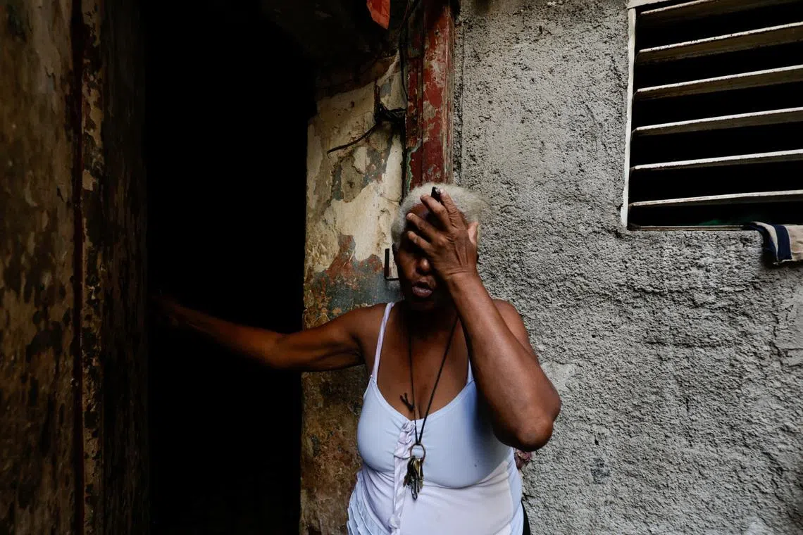 Felicia de la Caridad Alvarez reacts the moment power went out, as Cuba's state-run economy has descended into a full-blown crisis.