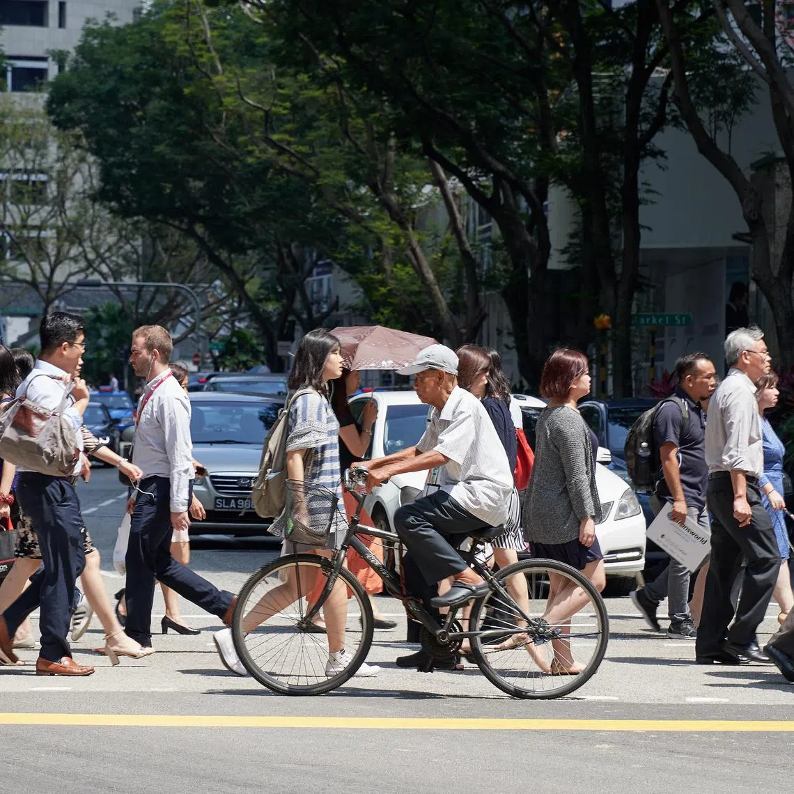 People crossing the road at the traffic light junction in the CBD area on 19 March 2018. Also seen crossing is an elderly man on his bicycle.
