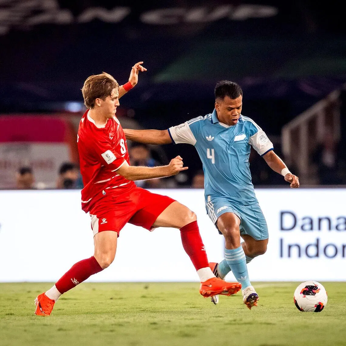 Lions defender Nur Adam Abdullah (right) taking on Indonesia’s Luke Vickery in the FIFA ASEAN Cup on Sept 25.