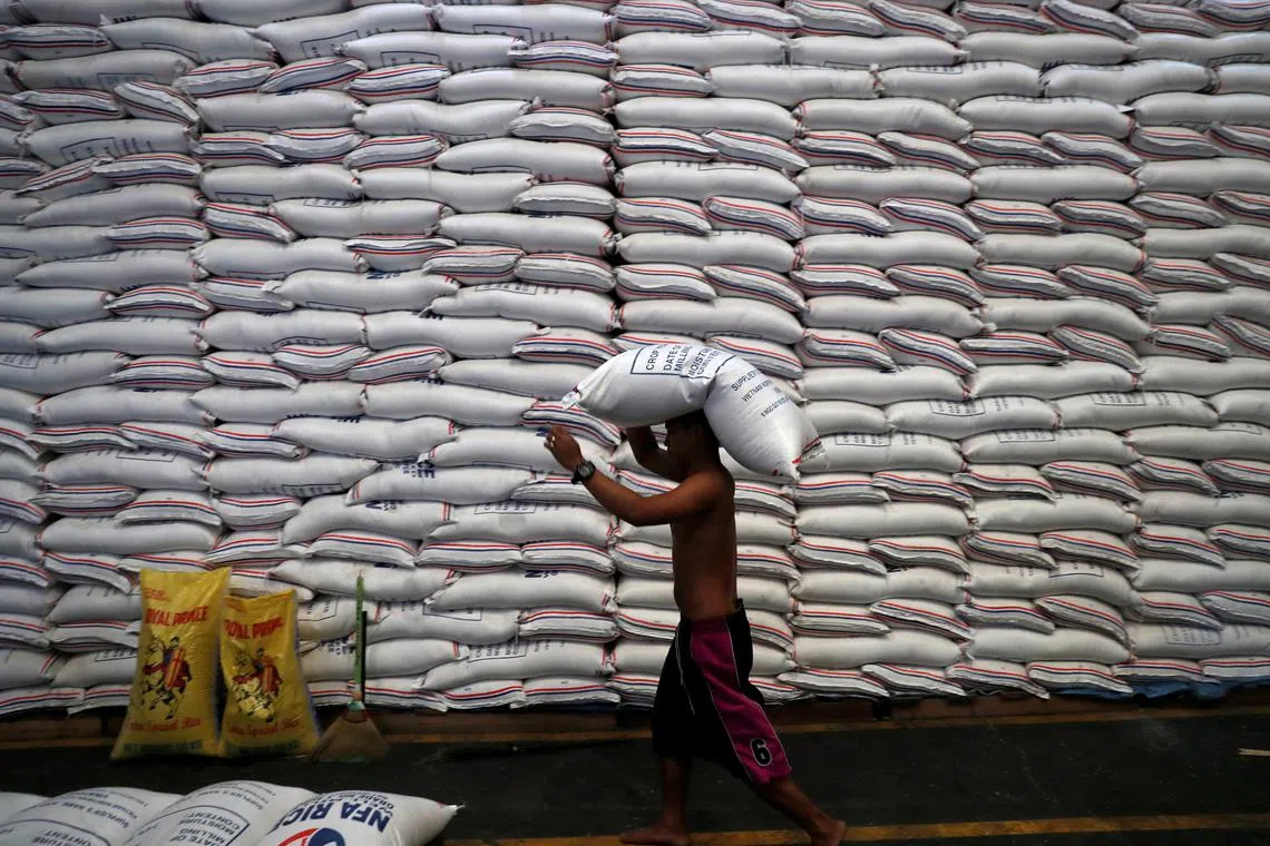A worker carrying a sack of rice inside a government rice warehouse at the National Food Authority in Quezon city, Metro Manila on Aug 9. 