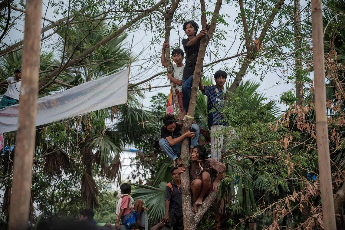 TOPSHOT - People watch as Hindu devotees takes part in a religious procession during the firewalk festival in Yangon on February 11, 2024. (Photo by SAI AUNG MAIN / AFP)