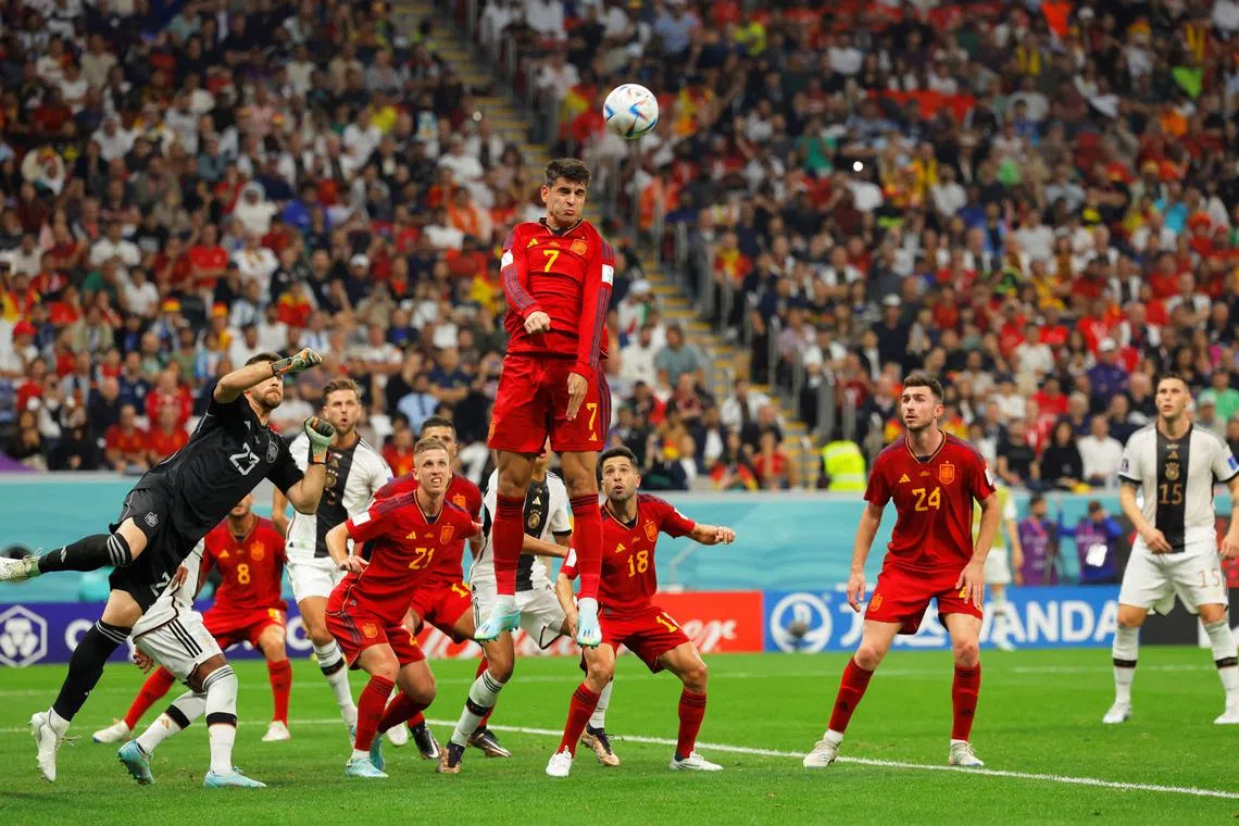 TOPSHOT - Spain's forward #07 Alvaro Morata (C) jumps to head the ball during the Qatar 2022 World Cup Group E football match between Spain and Germany at the Al-Bayt Stadium in Al Khor, north of Doha on November 27, 2022. (Photo by Odd ANDERSEN / AFP)