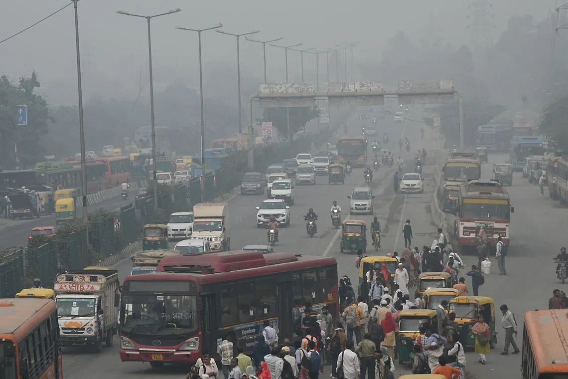 Commuters waiting for buses at a bus stop amid heavy smog in New Delhi, India, on Nov 4, 2023.