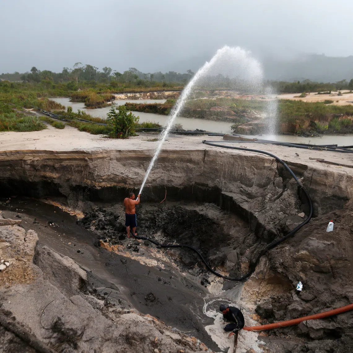 FILE PHOTO: Miners dig with pressure hoses near the town of Ikabaru, south of Venezuela, November 13, 2012. REUTERS/Jorge Silva/ File Photo