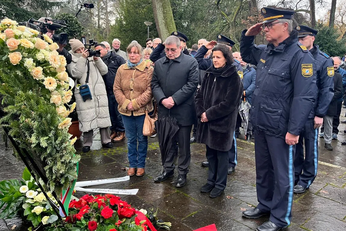 Police salutes in front of a wreath the day after two people, one a child, were killed in a knife attack, in Aschaffenburg, Germany, January 23, 2025. REUTERS/Tilman Blashofer