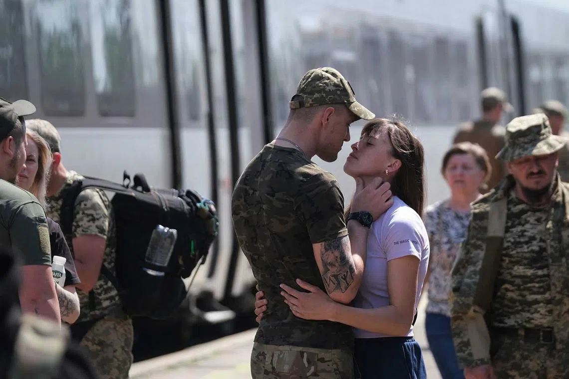 TOPSHOT - A couple embraces at the railway station in Kramatorsk, on May 20, 2023, amid the Russian invasion of Ukraine. (Photo by Sergey SHESTAK / AFP)