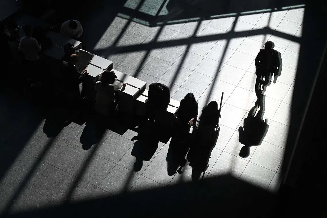 People rest in the lobby of an office building in Tokyo on Oct 30, 2025. 