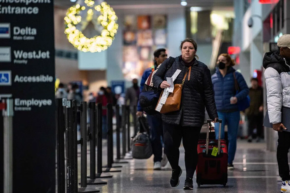 Travellers make their way through the terminal at Logan International Airport in Boston, Massachusetts, on Dec 23, 2022.