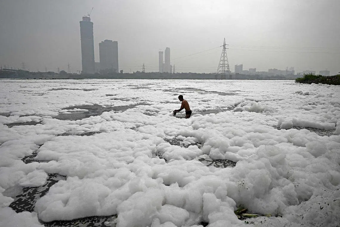 A man bathes in the polluted waters of river Yamuna laden with foam, on the eve of world environment day in New Delhi, India, on June 4.