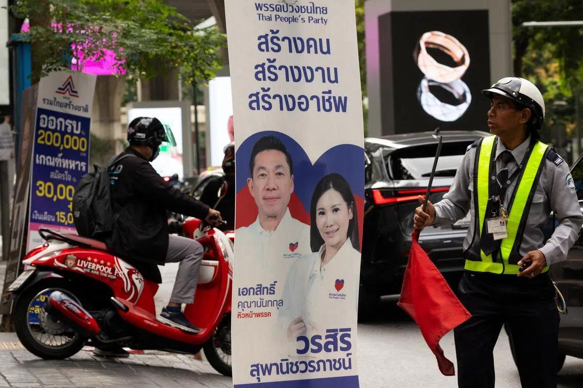 A security officer looks on next to the People's Party electoral campaign posters, before Thailand general elections on February 8, in Bangkok, Thailand, February 4, 2026. REUTERS/Maxim Shemetov