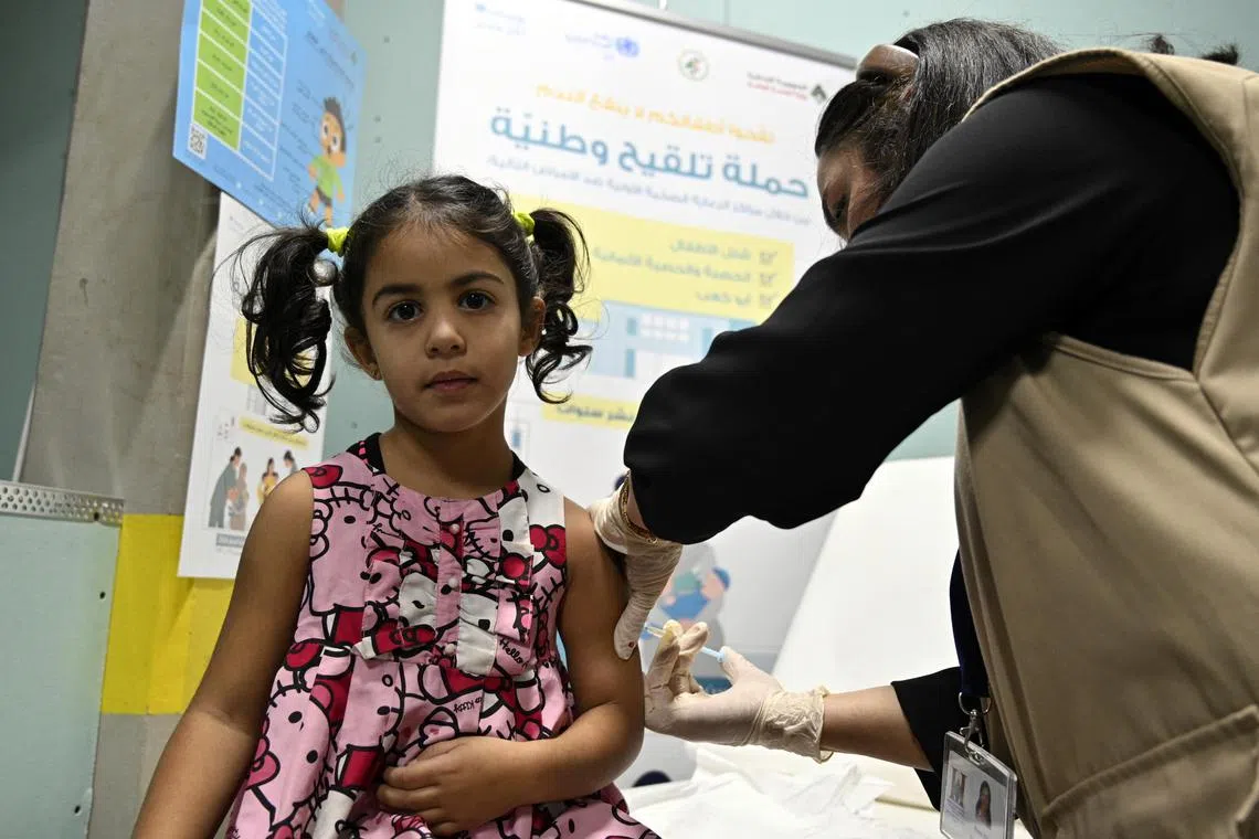 A health worker administering a measles vaccine to a child in Beirut, Lebanon, on Nov 14.