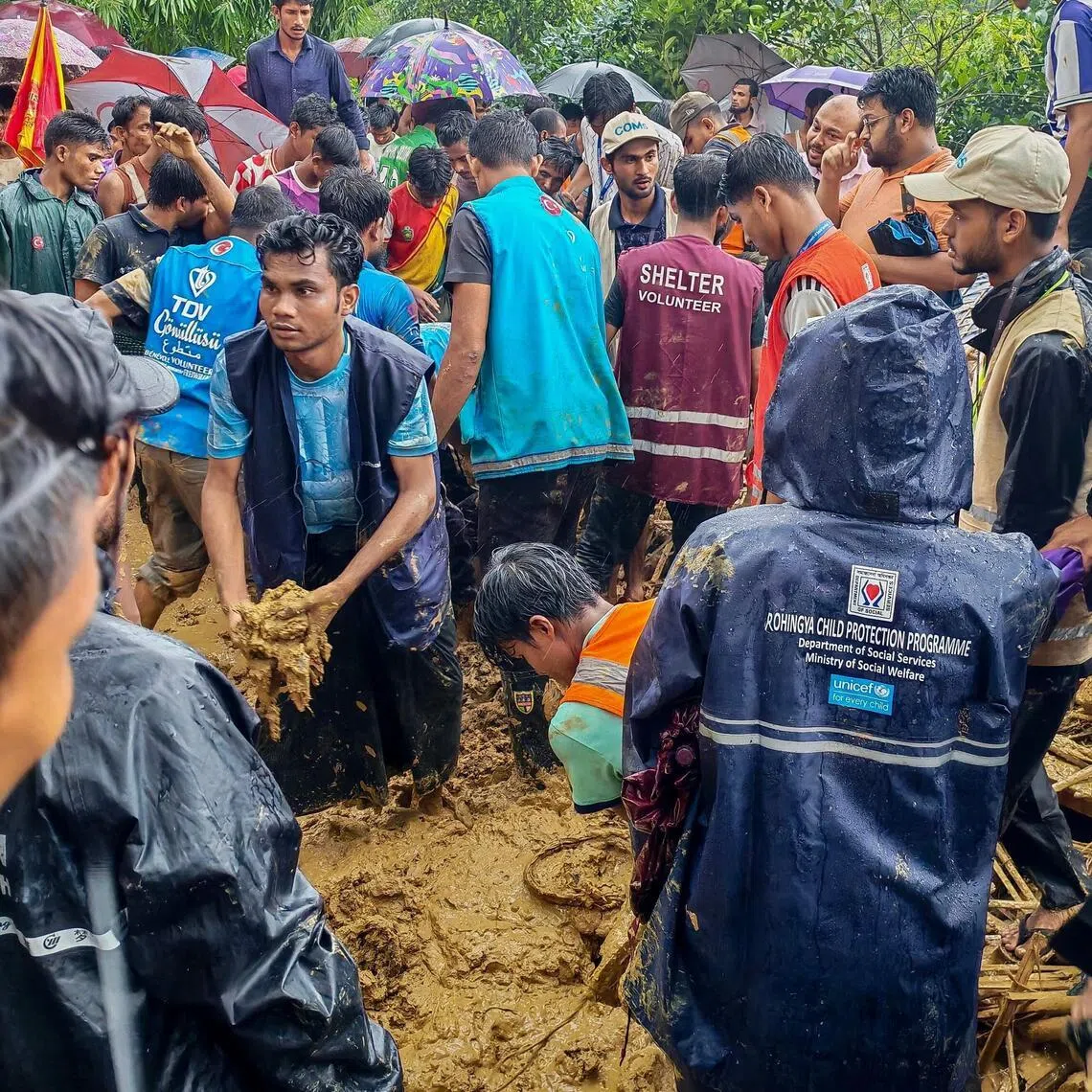 Bangladesh rescue personnel and volunteers work at the site of a landslide triggered by heavy rains at a school in the Kutupalong refugee camp in Cox’s Bazar on July 8.