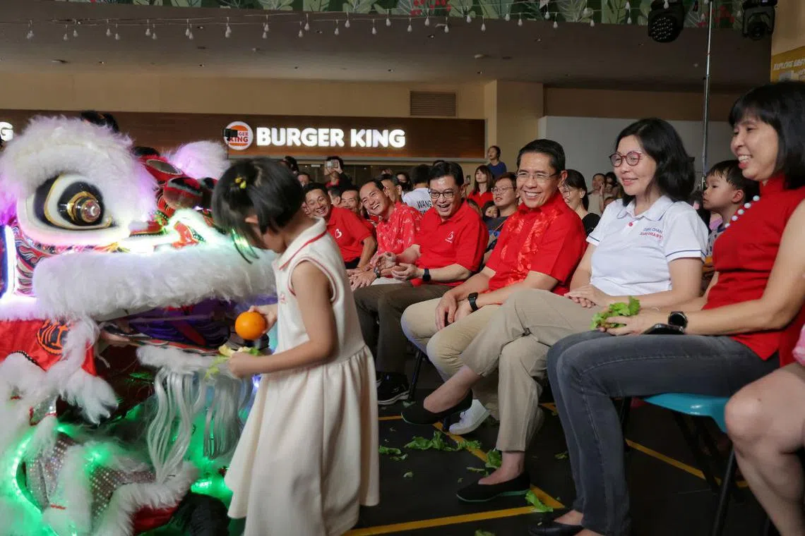 East Coast GRC's team of (from right) advisers Ms Jessica Tan and Ms Cheryl Chan, Minister Dr Maliki Osman, Deputy Prime Minister Heng Swee Keat, and Senior Minister of State Mr Tan Kiat How look on as a young girl retrieves a mandarin orange from the lion's mouth during a Chinese New Year carnival at Heartbeat@Bedok on Jan 25, 2025. 