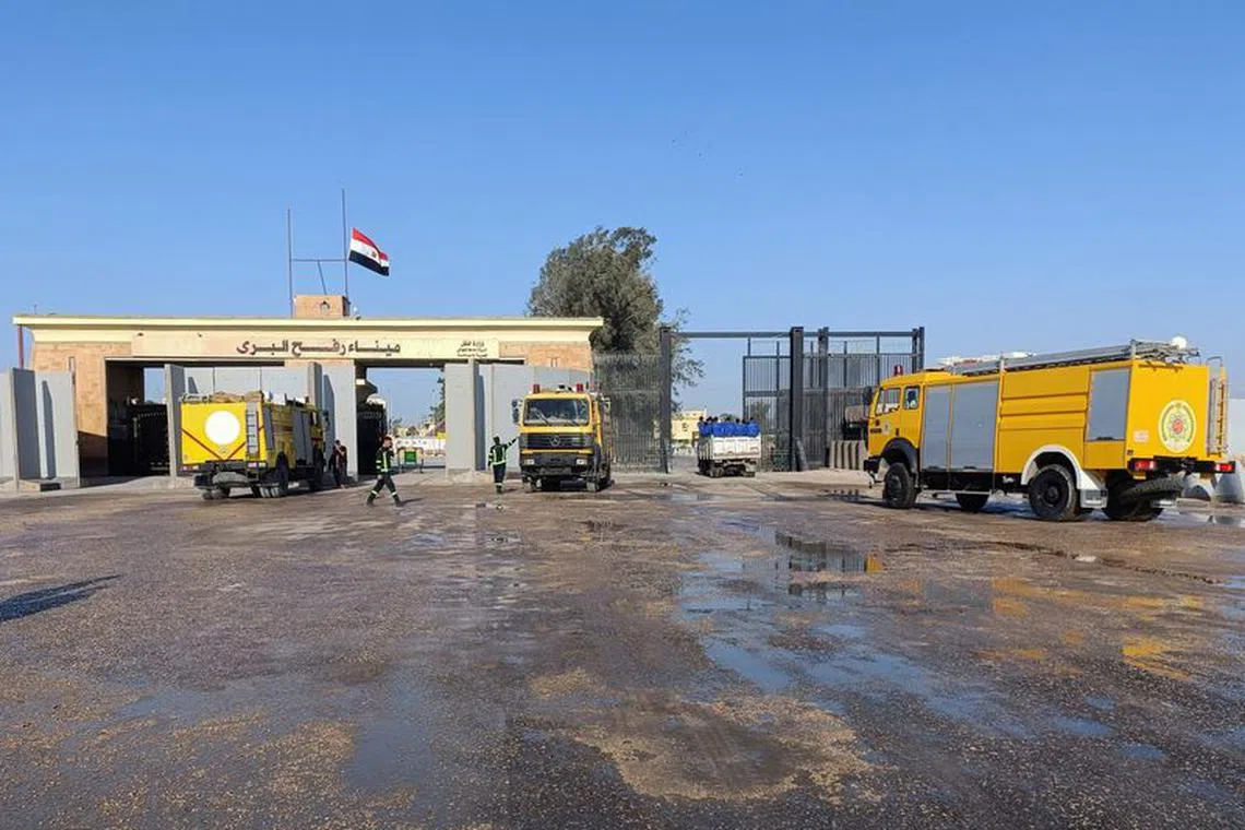 Egyptian fire trucks are pictured in front of the Rafah crossing from the Egyptian side, while trucks carrying humanitarian aid for Palestinians await for it to open to enter Gaza, amid the ongoing conflict between Israel and the Palestinian Islamist group Hamas, in Rafah, Egypt October 19, 2023. REUTERS/Stringer/file photo