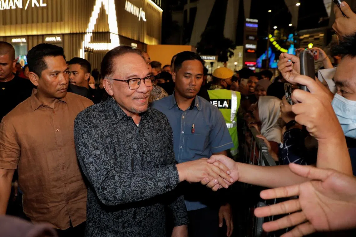 Malaysia Prime Minister Anwar Ibrahim greets people as he attends a premiere show of Anwar: The Untold Story, a film based on the period in Anwar's life when he became finance minister from 1991 until he was fired from the Cabinet in 1998, in Kuala Lumpur, Malaysia May 8, 2023. REUTERS/Hasnoor Hussain