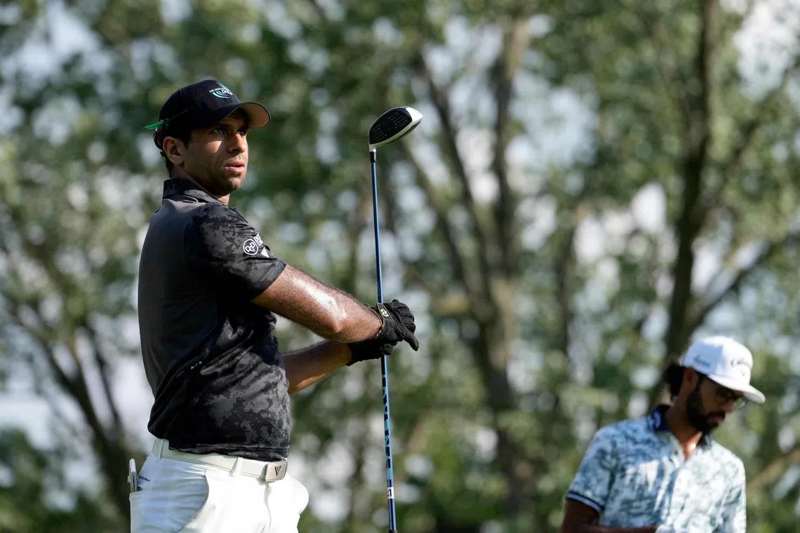 Aaron Rai of England playing his shot from the 14th tee as Akshay Bhatia of the United States looks on during the third round of the Rocket Mortgage Classic at Detroit Golf Club on June 29.  The co-leaders shot four-under 68s.