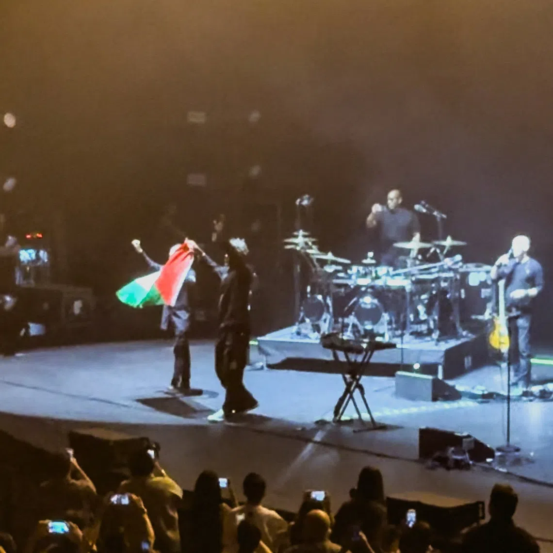 Robert Del Naja and Grant Marshall from Massive Attack stand with a Palestinian flag onstage at the end of their performance in Singapore on July 29, 2026, in this screengrab from video obtained from social media.