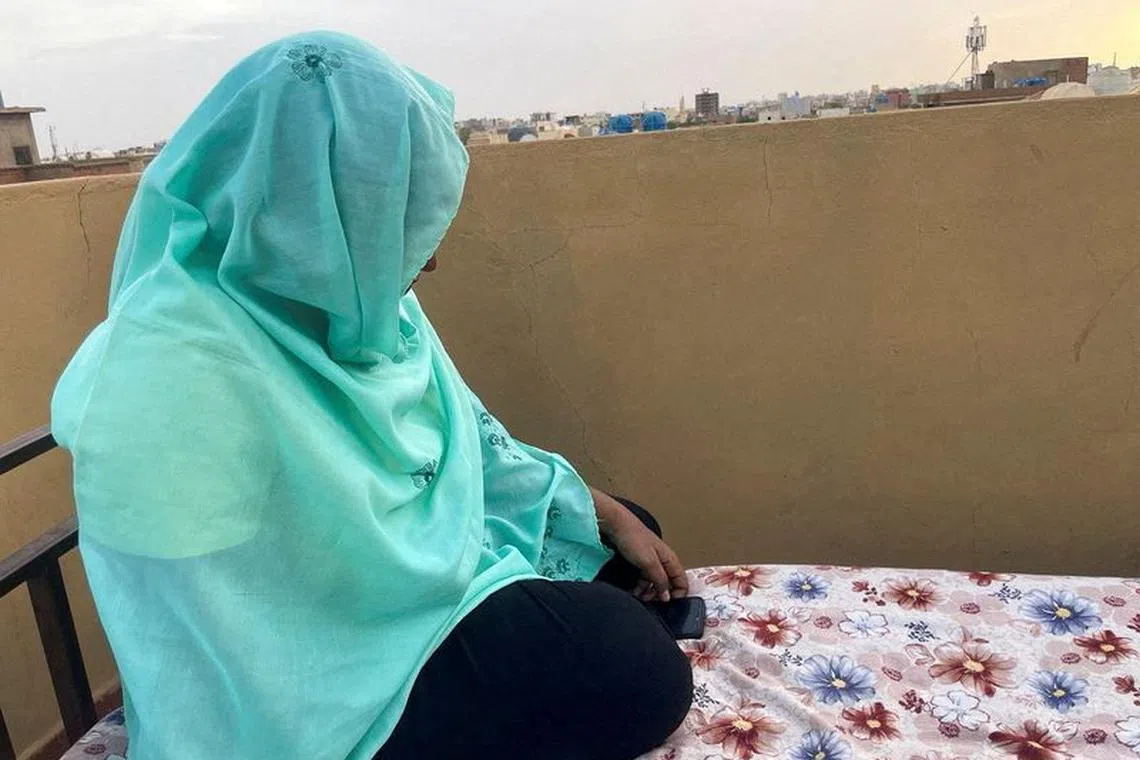 FILE PHOTO: Heba checks her phone for news of her relatives as she sits on the rooftop of her house during the conflict in Khartoum, Sudan, April 30, 2023. REUTERS/El Tayeb Siddig