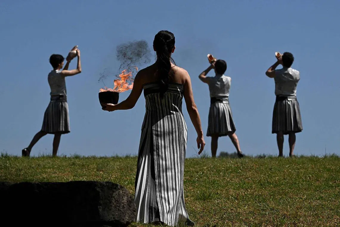 Greek actress Mary Mina, playing the role of the High Priestess, holding the Olympic flame during the rehearsal of the flame lighting ceremony for the Paris 2024 Olympics Games at the ancient temple of Hera on the Olympia archeological site, birthplace of the ancient Olympics in southern Greece, on April 15, 2024. 