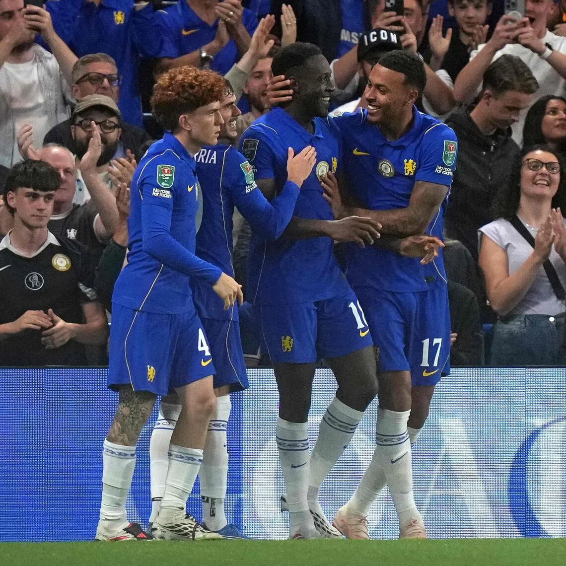 Danny Welbeck celebrates scoring the opening goal for Chelsea with teammate Morgan Rogers (right).
