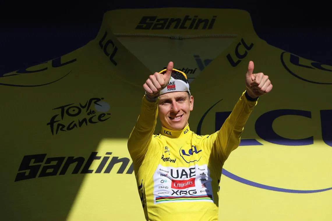 Cycling - Tour de France - Stage 10 - Aurillac to Le Lioran - Le Lioran, France - July 14, 2026 UAE Team Emirates - XRG's Tadej Pogacar celebrates on the podium wearing the yellow jersey after winning stage 10 REUTERS/Gonzalo Fuentes