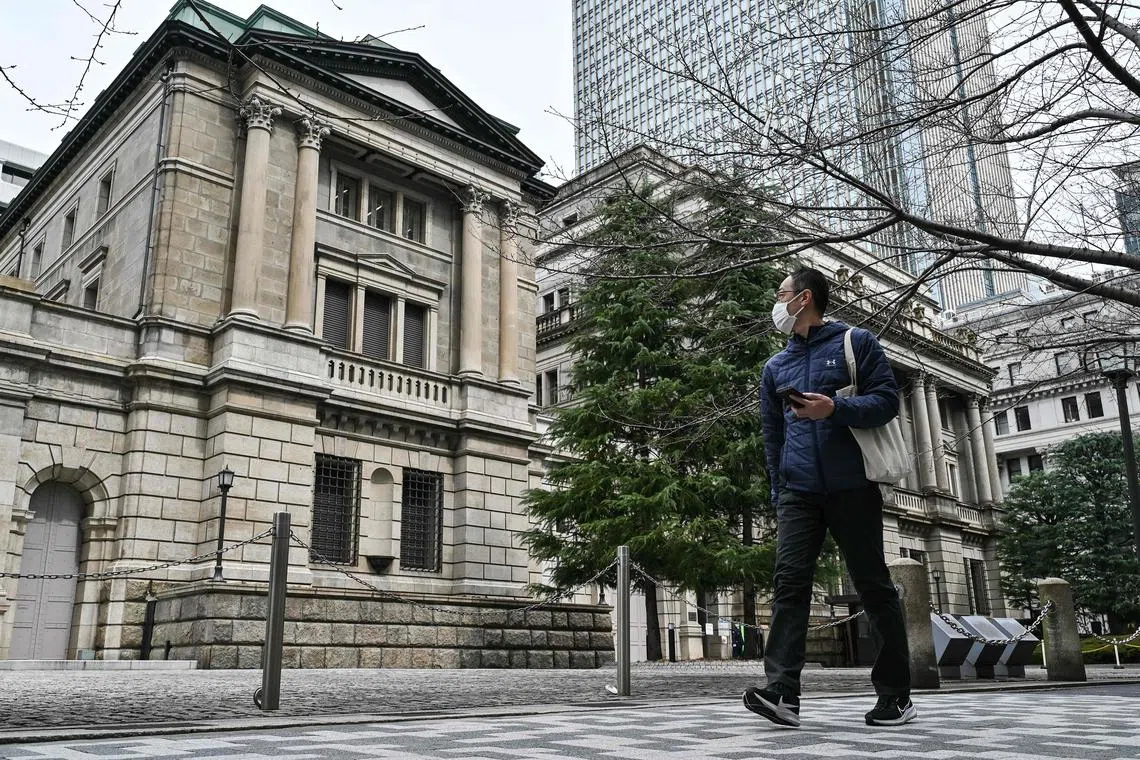 A man walks past the Bank of Japan (BoJ) headquarters complex in central Tokyo on March 19, 2024. Japan's central bank was widely expected later on March 19 to scrap its maverick negative interest rate policy and hike borrowing costs for the first time in 17 years, according to economists and media reports. (Photo by Richard A. Brooks / AFP)