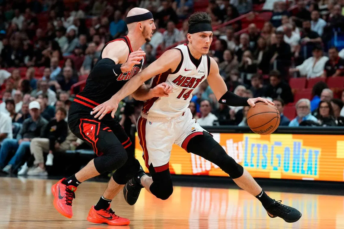 Tyler Herro of the Miami Heat dribbles the ball against Alex Caruso of the Chicago Bulls in the first quarter during the play-in tournament at Kaseya Centre.