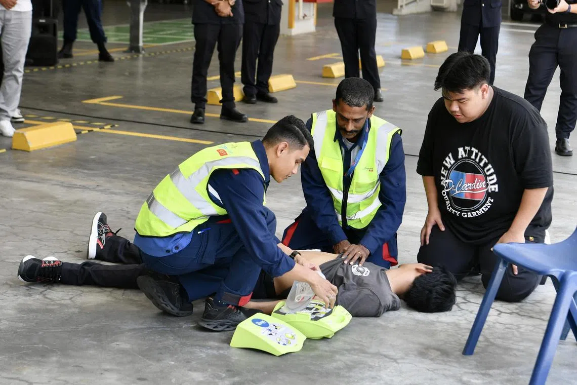 SingPost personnel demonstrating the use of an AED, at the launch of the SingPost AED-on-Wheels programme on March 13, 2023.