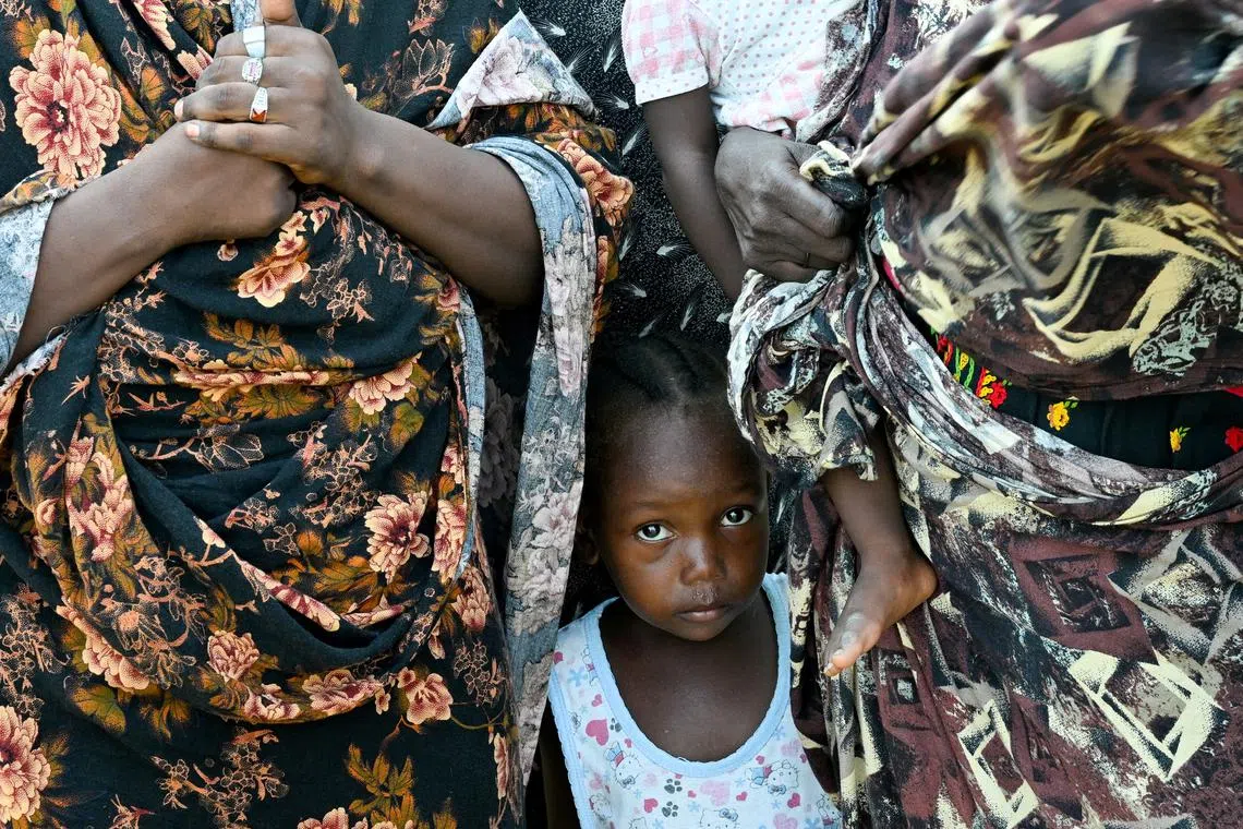 FILE PHOTO: A child stands between two women at a school turned into a shelter, in Port Sudan, Sudan, August 29, 2024. REUTERS/Abrahim Mohammed Ishac/File Photo