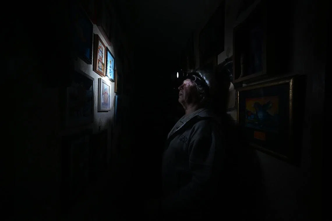 Physicist Igor Zhuk, 70-years-old, wearing his headlamp during a power cut in his building, in the north of the Ukrainian capital of Kyiv, Nov 5, 2022.