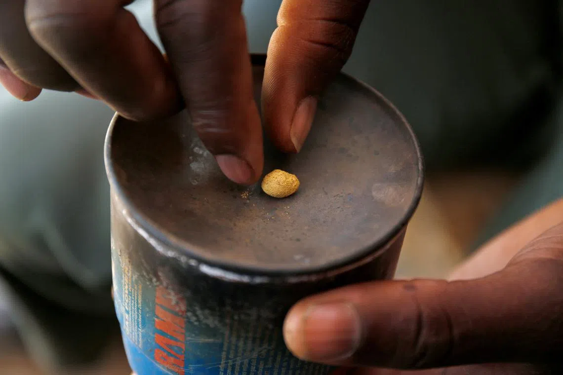 FILE PHOTO: An artisanal gold miner picks up a gold nugget at an unlicensed mine in Gaoua, Burkina Faso, February 13, 2018.Picture taken February 13, 2018. REUTERS/Luc Gnago/File Photo