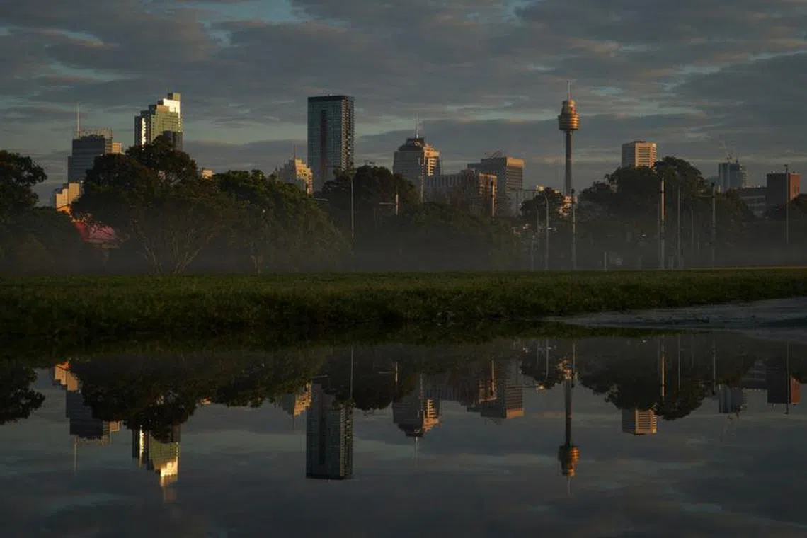 FILE PHOTO: The city skyline is reflected in a puddle at sunrise following rainy weather in Sydney, Australia, August 28, 2022. REUTERS/Loren Elliott