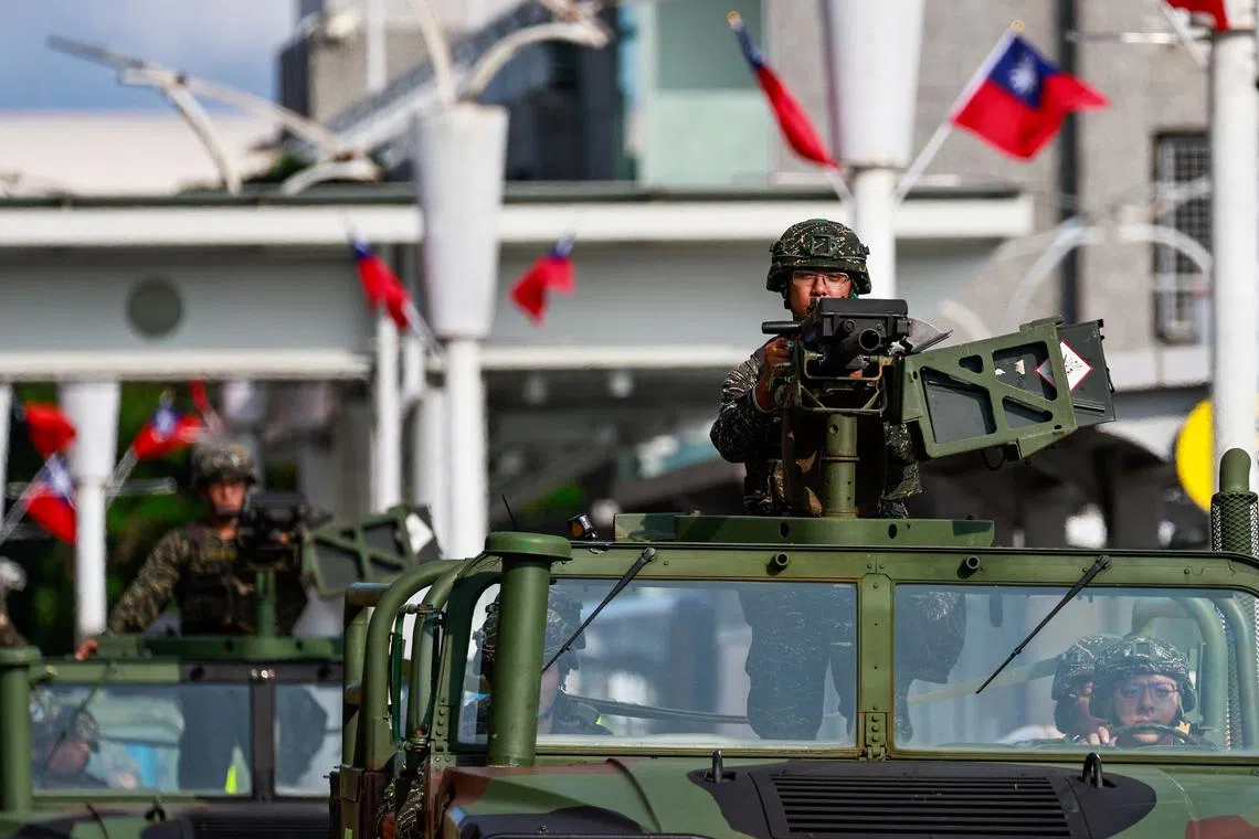Military vehicles patrol outside Songshan Airport in Taipei, on Oct 14.