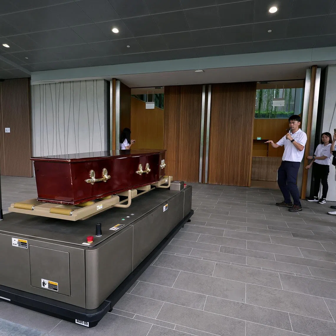 Demonstration of the automated guided vehicle (AGV) carrying a casket into position from the unloading area into the service hall at Mandai North Crematorium on July 23, 2025. ST PHOTO: KEVIN LIM ssmandai28