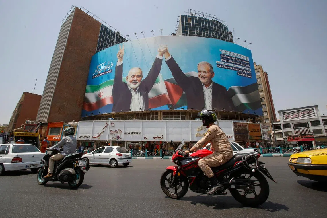 Vehicles drive past a huge billboard depicting Iranian President Masoud Pezeshkian (R) and slain leader of the Palestinian Hamas group Ismail Haniyeh at Tehran's Valiasr square on August 8, 2024, amid regional tensions during the ongoing war between Israel and Hamas in the Gaza Strip. (Photo by AFP)